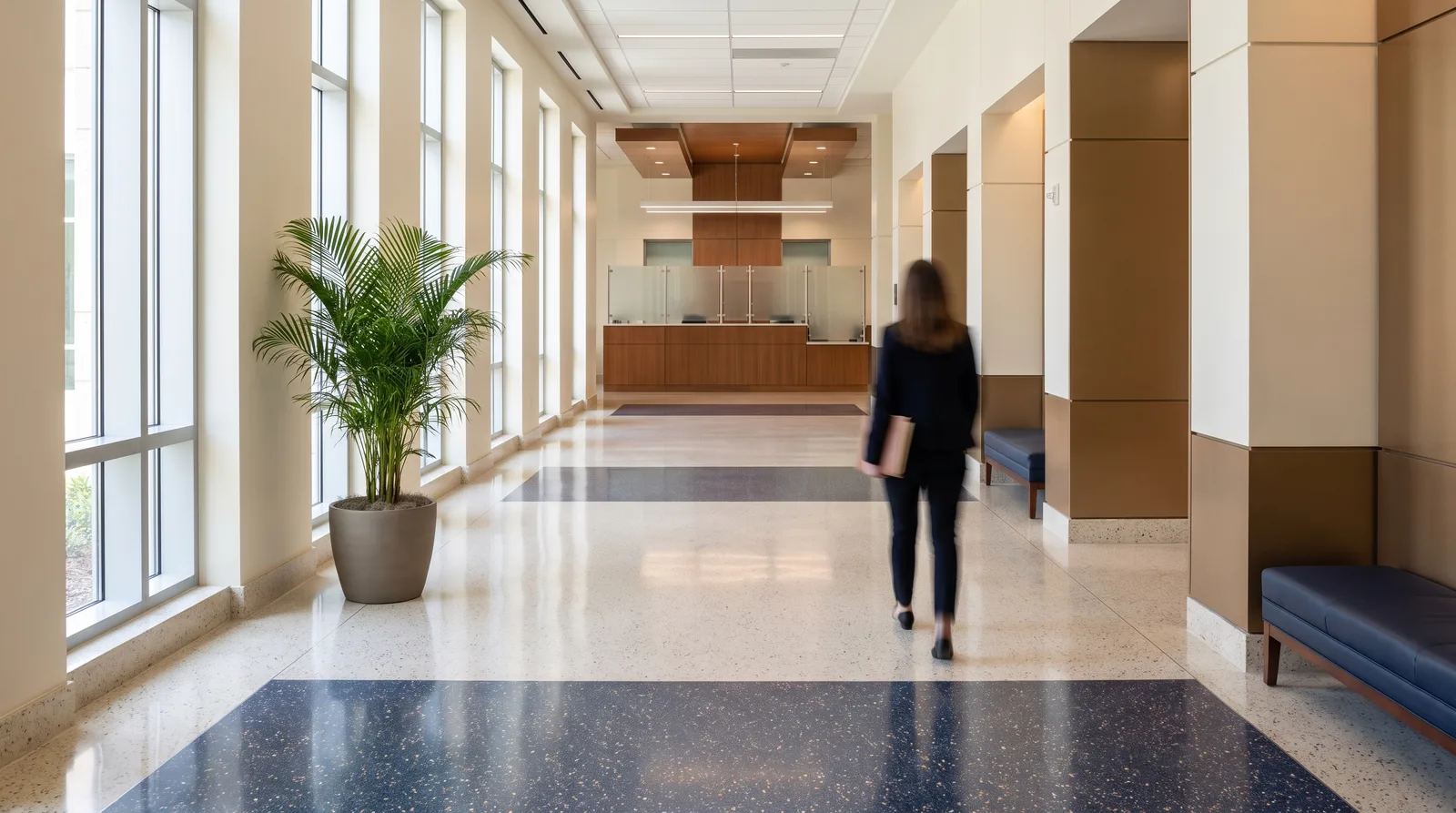 A person carrying a folder down a bright Florida county courthouse hallway toward the clerk's service counter